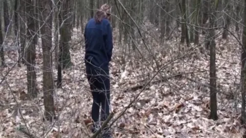 Chained Brunette Bending and Reaching in Forest