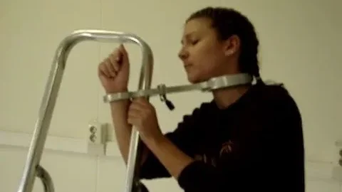Strict Metal Restraint Pins Girl to Ladder